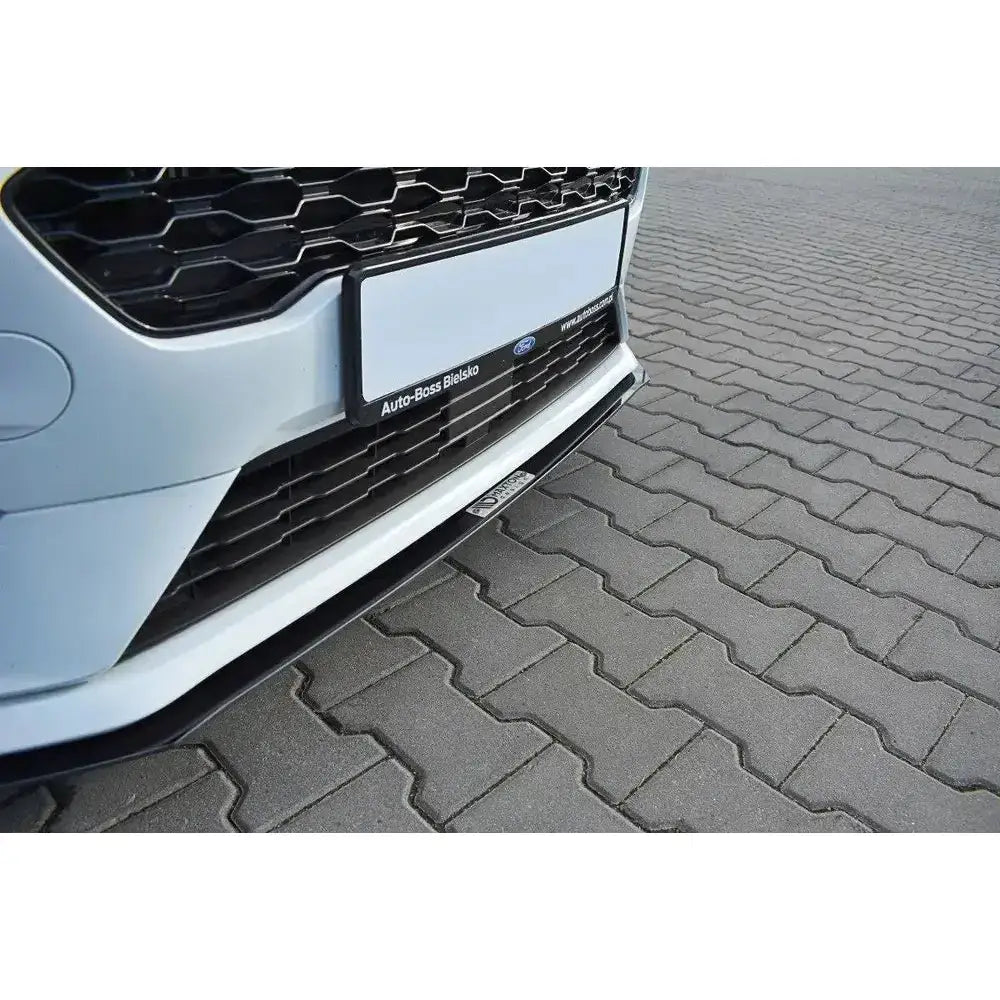 Frontspoiler Racing V.2 på Ford Fiesta MK8 ST med sort grill og svart spoiler mot belegningsstein.