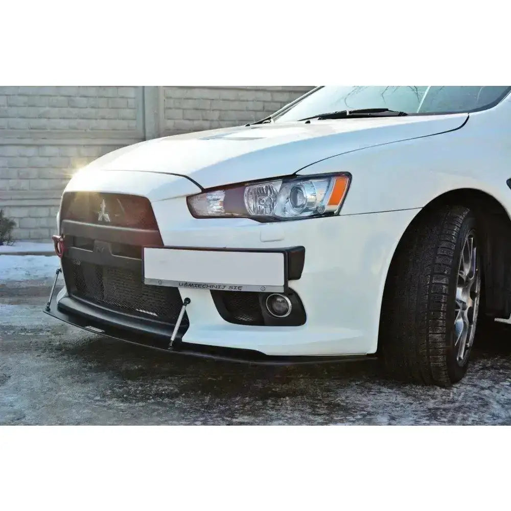 Front splitter på Mitsubishi Lancer Evo X med sorte aerodynamiske stropper og detaljerte frontlykter.
