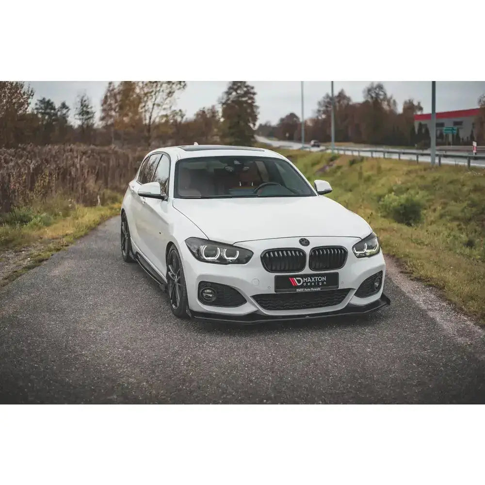 Frontspoiler på BMW 1 F20 M-Pack Facelift med svarte detaljer parkert på landevei.