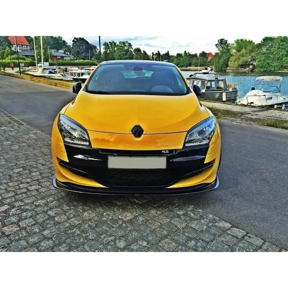 Frontsplitter på gul Renault Megane 3 Rs V.2 sett forfra med svarte detaljer ved en brygge.