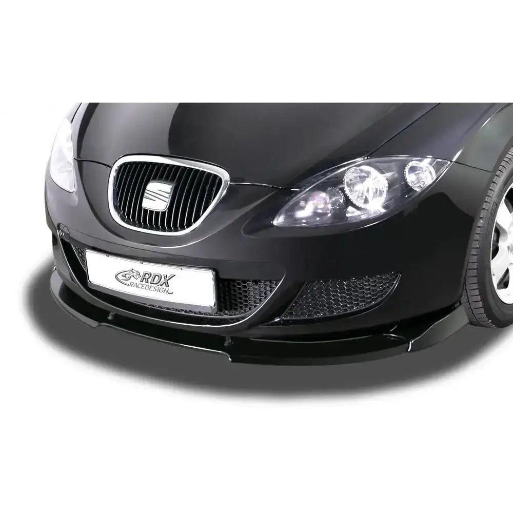 Frontleppe Seat Leon 1P i blank plast montert på sort bil, sett fra skrå front med synlig grill og felg.