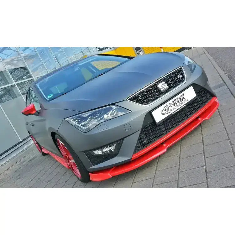 Frontspoiler på Seat Leon 5F FR Cupra med røde detaljer, sett forfra og fra siden på brostein.