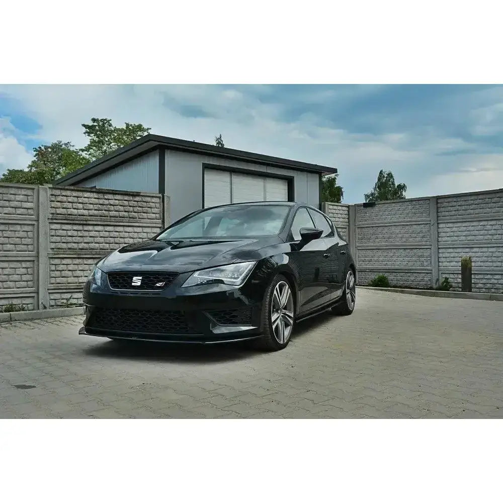 Frontleppe Seat Leon III Cupra vist på sort bil parkert foran grå garasje og murvegg.