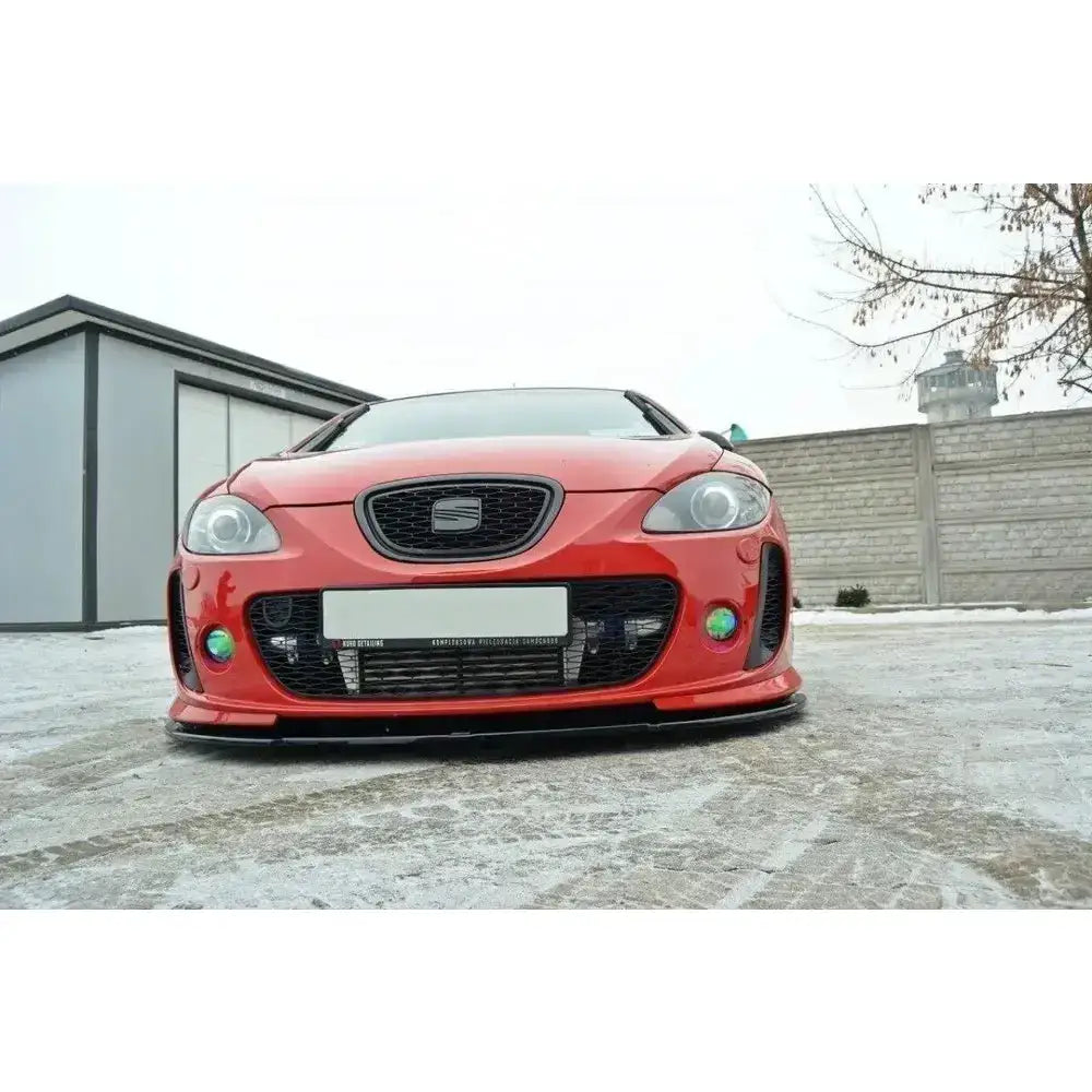 Frontsplitter på rød Seat Leon Mk2 fra Ms Design med grønne tåkelys, svart grill og snø under bilen.