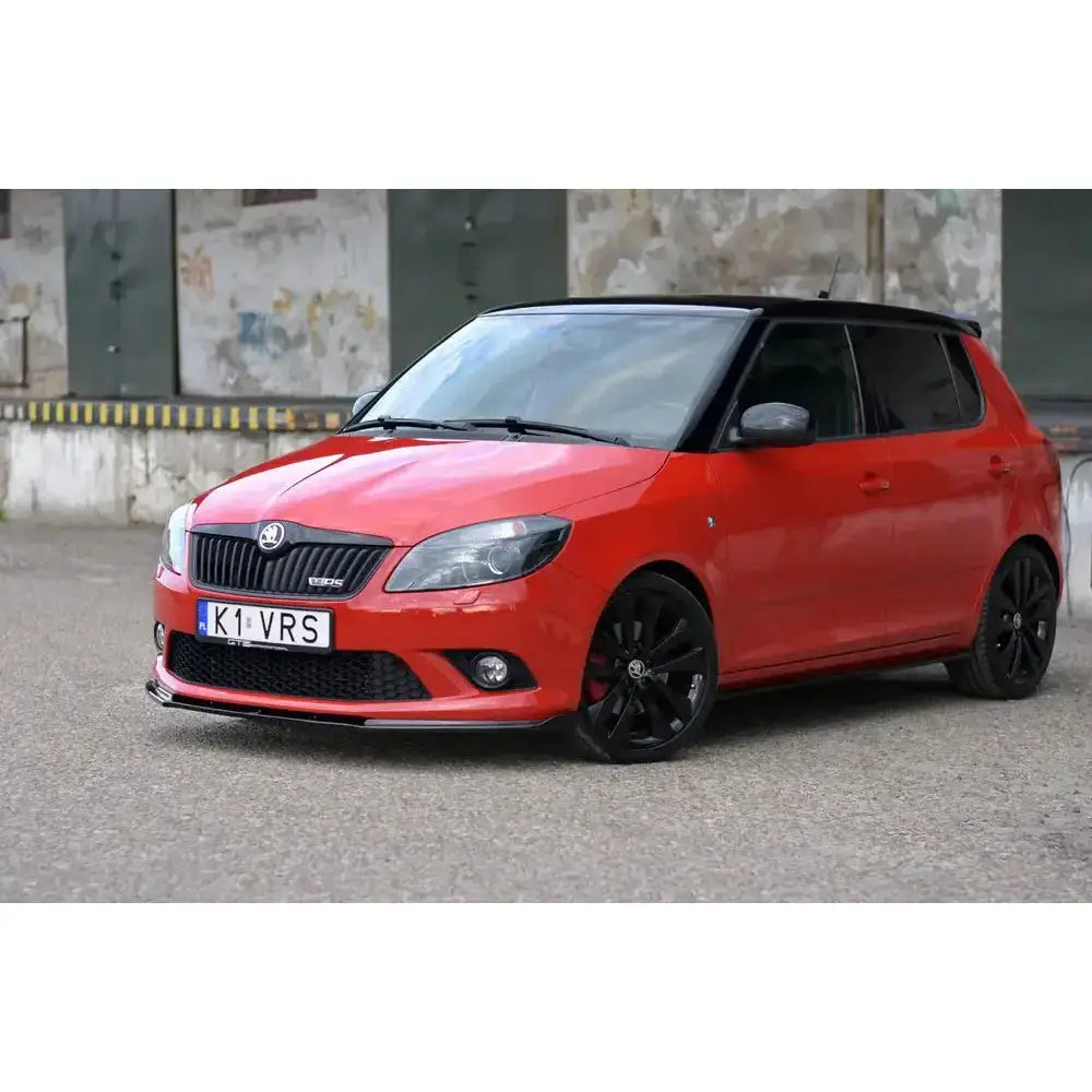 Frontspoiler på rød Skoda Fabia Mk2 RS med svarte felger og sort tak, sett skrått forfra.