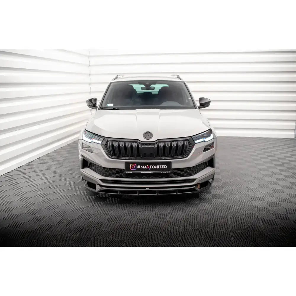 Frontsplitter på Skoda Karoq Sportline Mk1 Facelift hvit SUV med svarte detaljer og tent LED-lys.