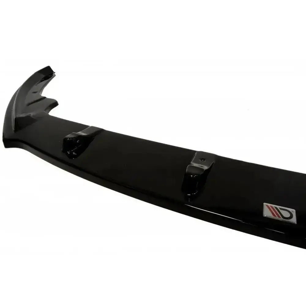 Front splitter til Skoda Rapid i sort blank plast med monteringspunkter og logo, sett skrått ovenfra.