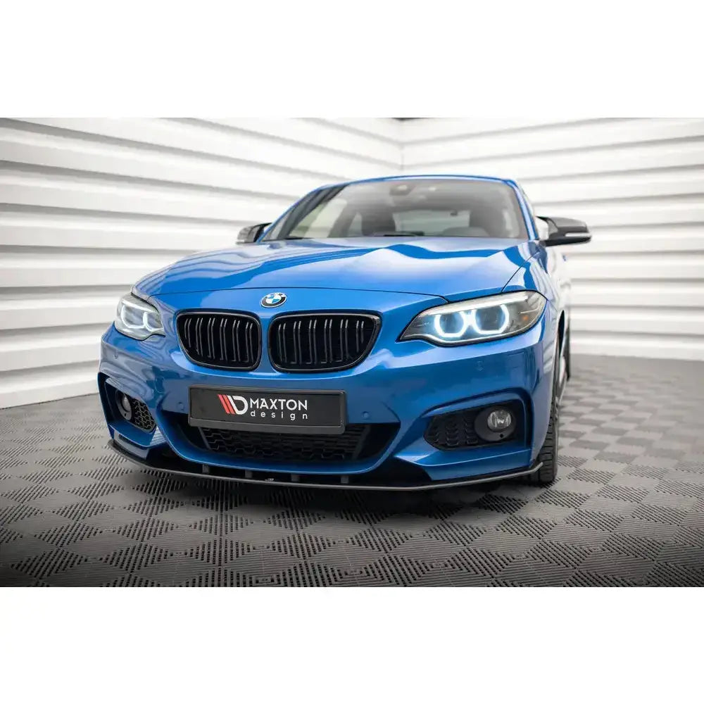 Front lip på blå BMW 2 Serie M-Pack F22 med LED-lykter og svart grill i lyst rom.