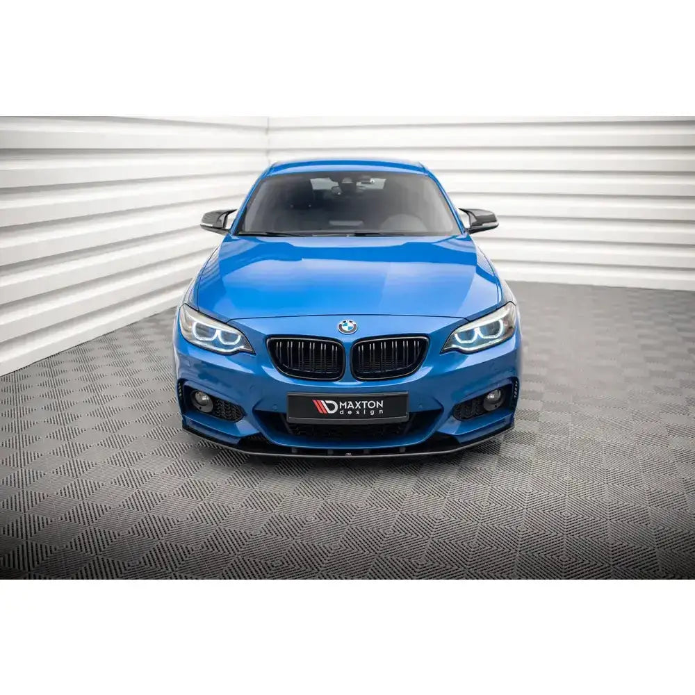 Frontspoiler på blå BMW 2 Serie M-Pack F22 med svarte detaljer, fotografert forfra i studio.