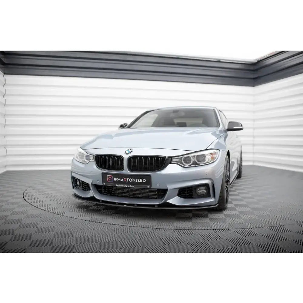Frontspoiler på BMW 4 Coupe F32 med M-Pack, vist forfra i lyst rom med sjakkmønstret gulv.