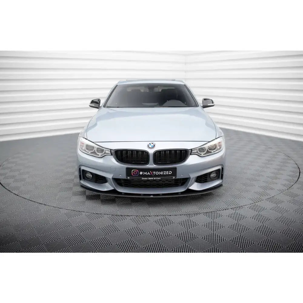 Frontsplitter på BMW 4 Coupe M-Pack F32 med sorte luftinntak, doble frontlykter og grått studiogulv.