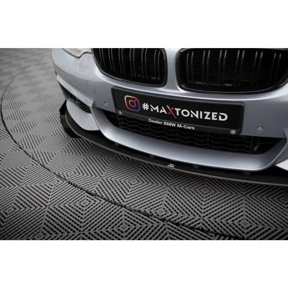 Front lip Street Pro med flaps på sølv BMW 4 Coupe F32, sort grill og spoiler, stående på mønstret gulv.