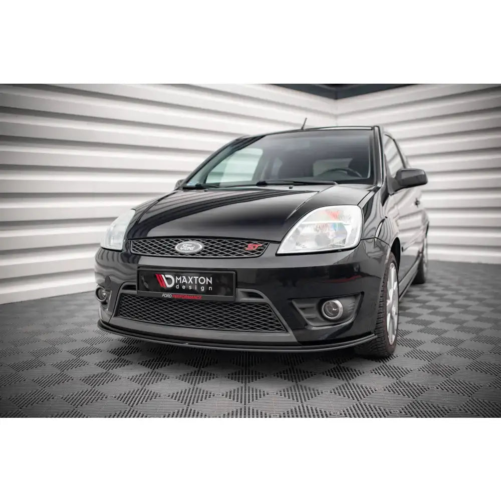 Frontspoiler Street Pro Ford Fiesta ST Mk6 montert på sort bil med synlig frontgrill og lykter.
