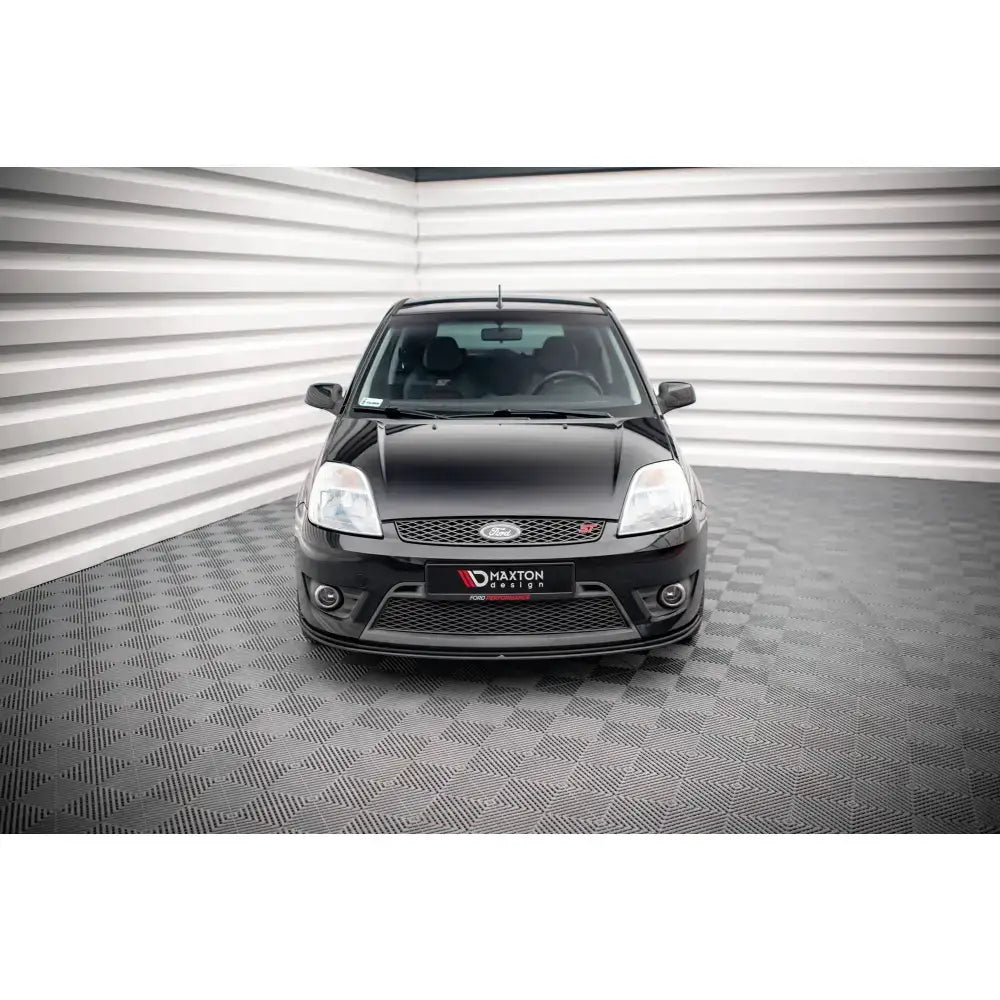Frontsplitter Street Pro Ford Fiesta ST Mk6 montert på sort bil, sett forfra i lyst studio.