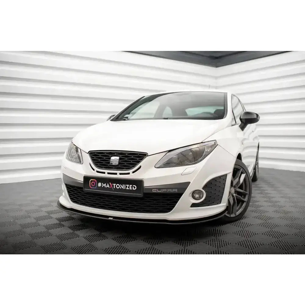 Frontsplitter på hvit Seat Ibiza Sport Coupe Mk4 med sorte detaljer og mørke felger i lyst rom.