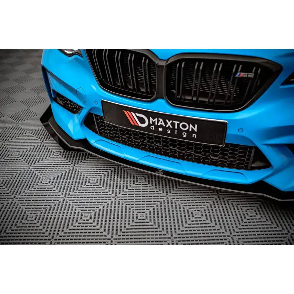 Frontsplitter til BMW M2 Competition F87 med svart design og sportslige detaljer, sett fra lav vinkel.