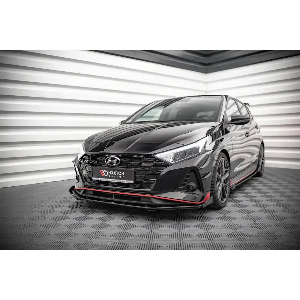 Frontsplitter på Hyundai I20 N Mk3 Street Pro V.1 med røde detaljer, sett skrått forfra innendørs.