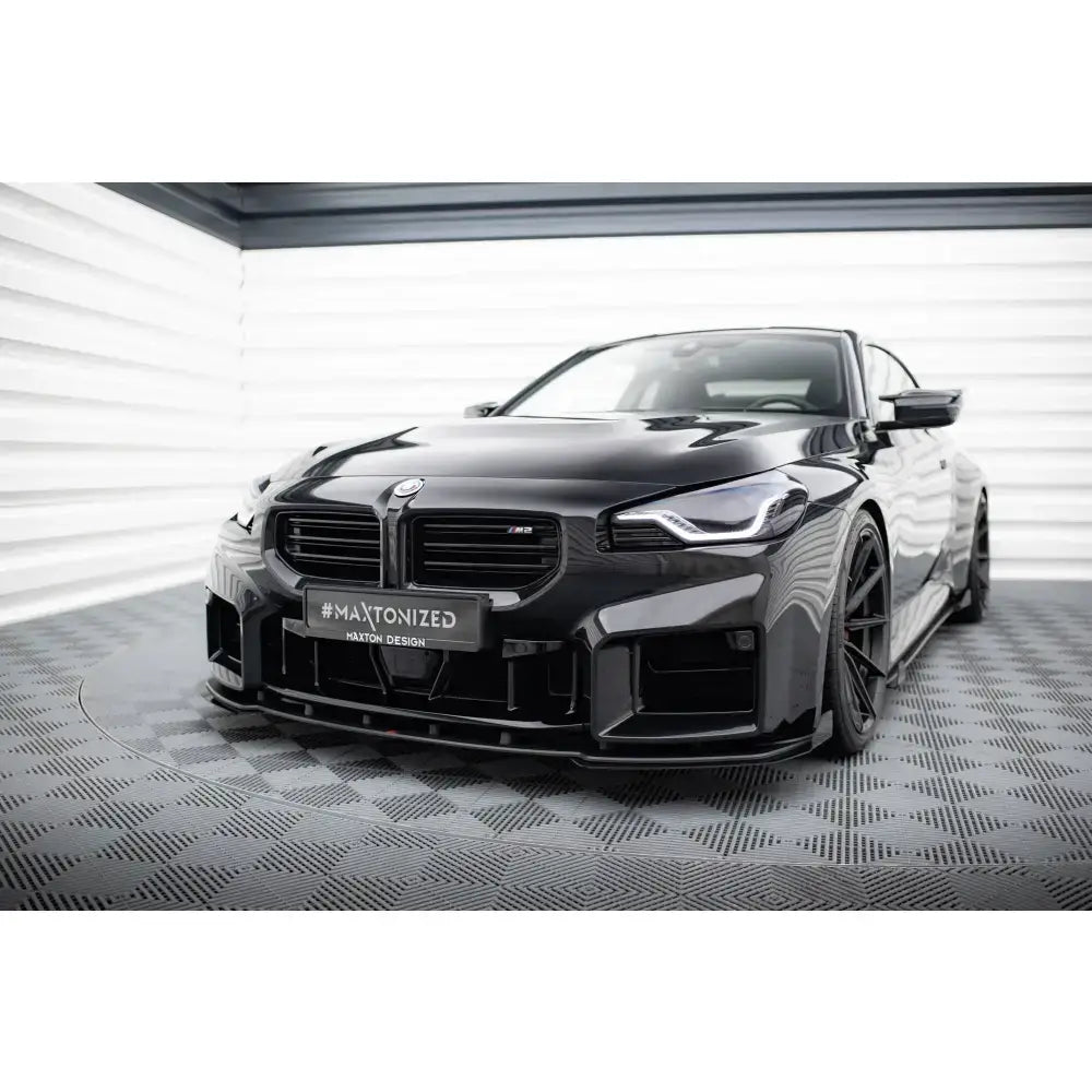 Frontspoiler Street Pro V1 med flaps på BMW M2 G87, sett forfra i lyst rom.