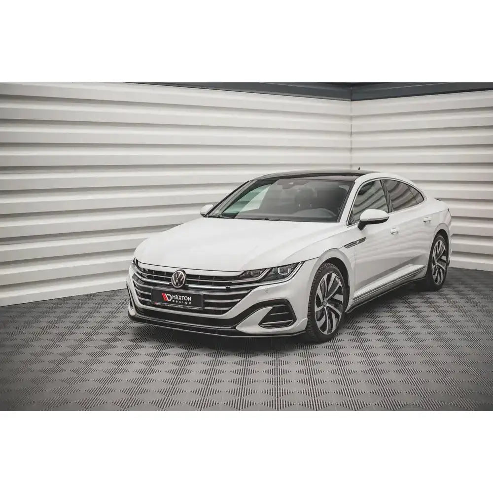 Frontsplitter på Volkswagen Arteon R-Line Facelift med sorte detaljer og store felger innendørs.