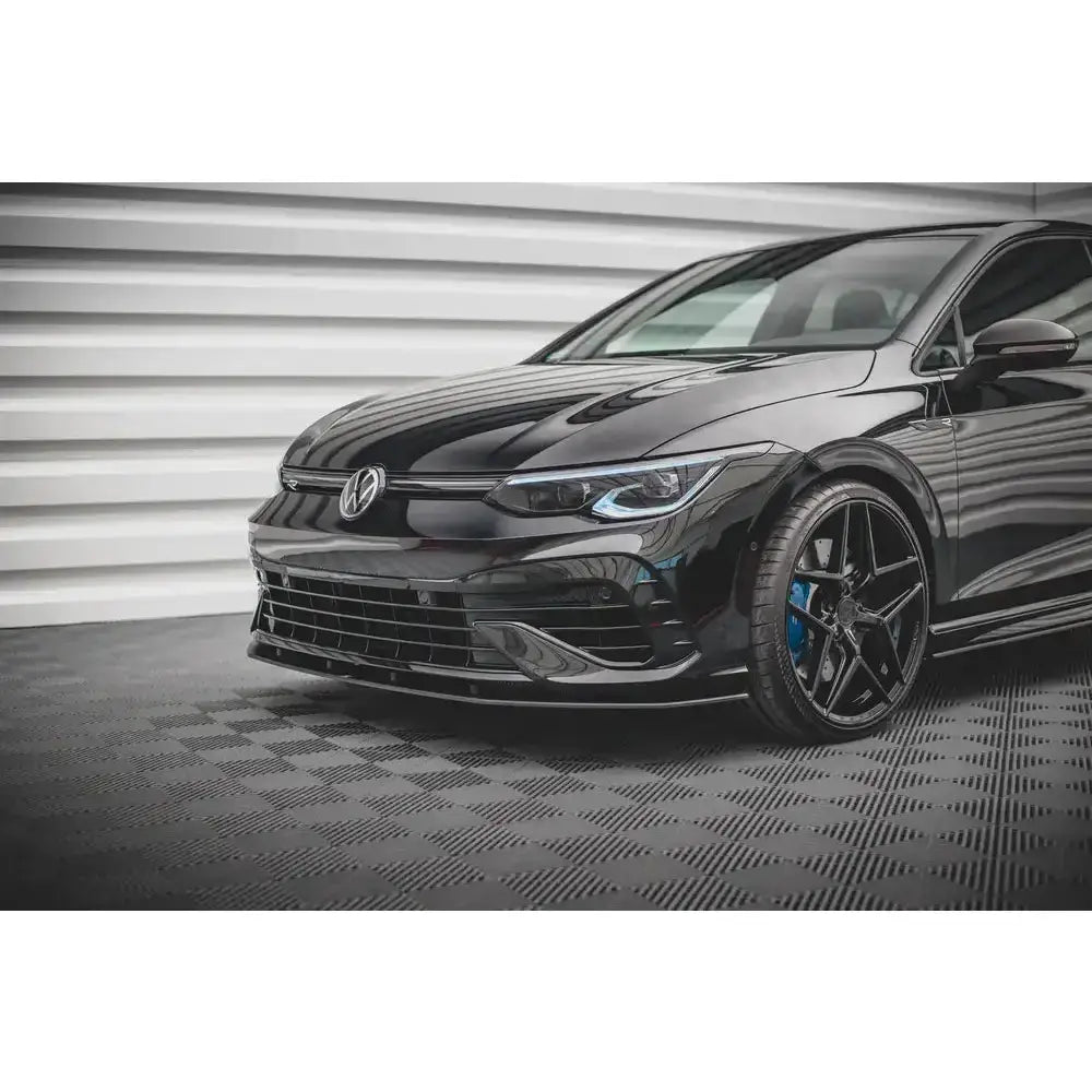 Front lip Street Pro Volkswagen Golf R Mk8 sett skrått forfra med aluminiumsfelger og blå bremsekalipere.