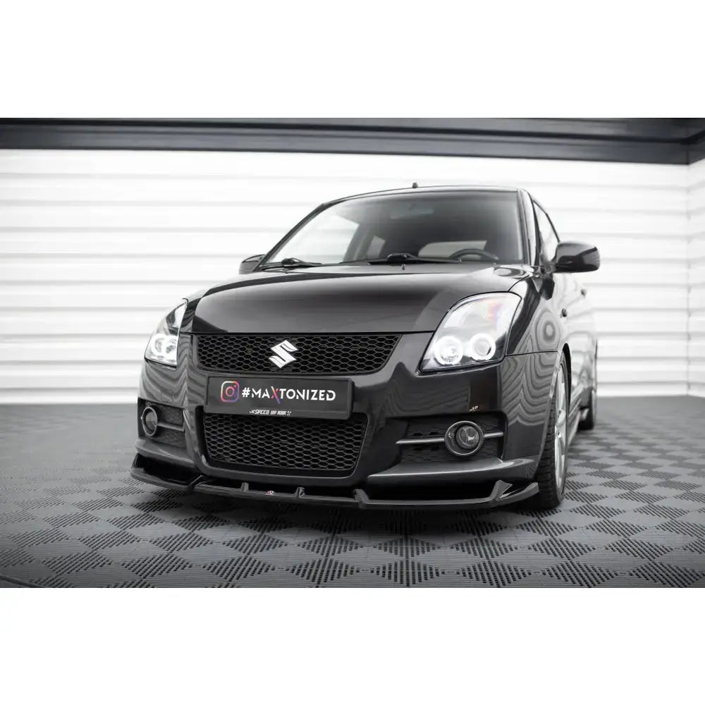 Frontspoiler på Suzuki Swift Sport Mk4 med markert frontsplitter og LED-lykter i moderne miljø.