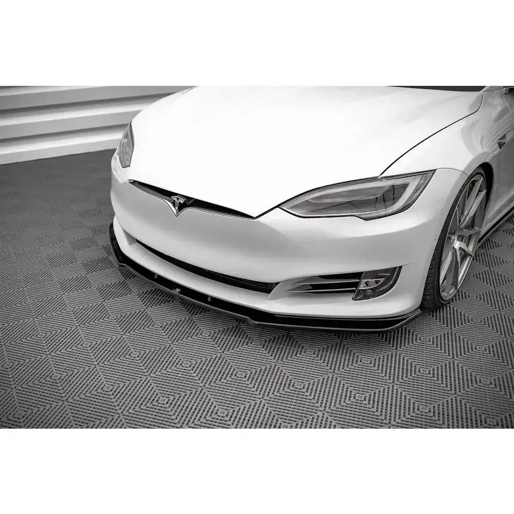 Frontsplitter på sort frontspoiler montert på Tesla Model S Facelift, vist i halvprofil på grått gulv.