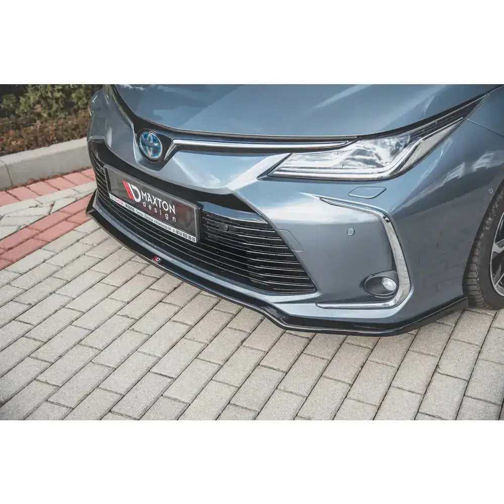 Front lip på Toyota Corolla XII Sedan, sort frontleppe montert på grå bil med synlig grill og tåkelys.