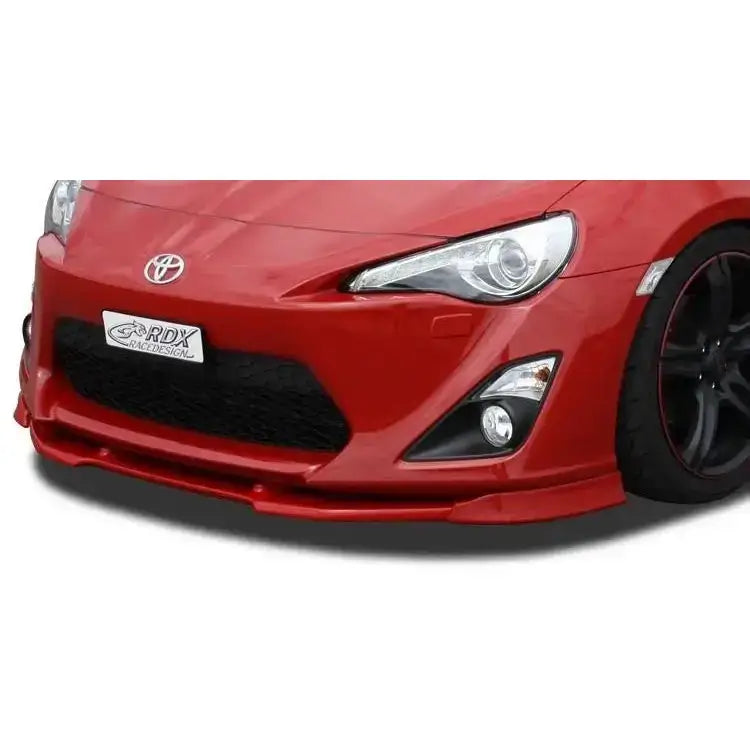 Frontleppe Toyota GT86 i rød farge med lavt plastskjørt, store frontlykter og sportsfelg, sett forfra.