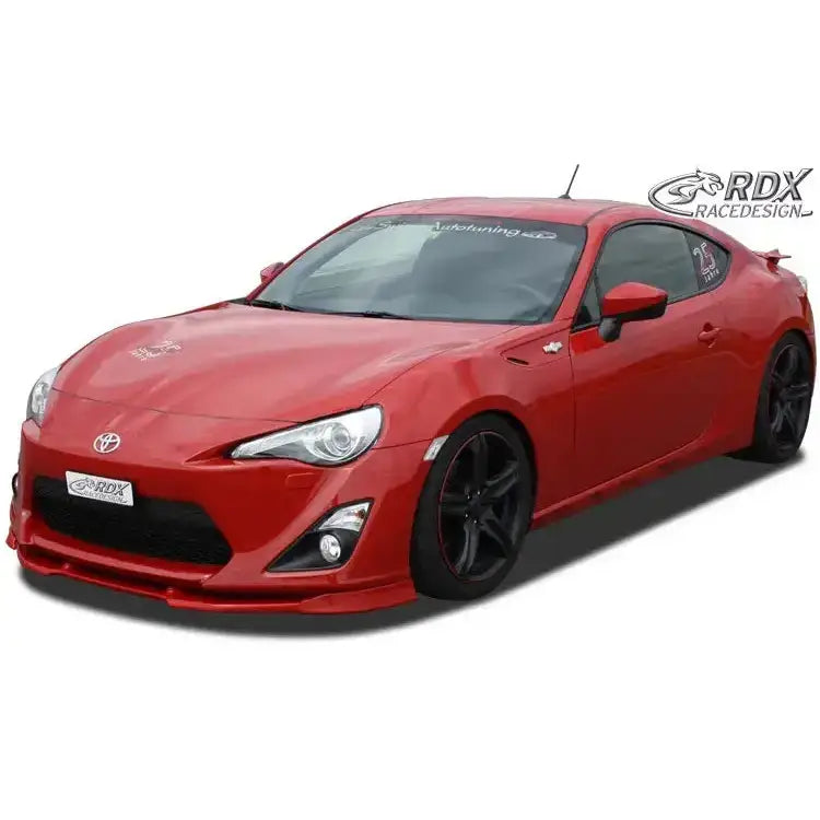 Front splitter på Toyota GT86 rød sportsbil med sorte felger og senket understell mot hvit bakgrunn.