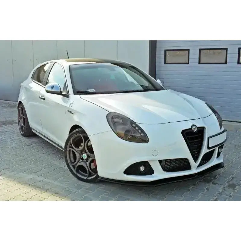 Frontspoiler på Alfa Romeo Giulietta V.1 montert på hvit bil med sorte felger foran garasjeport.