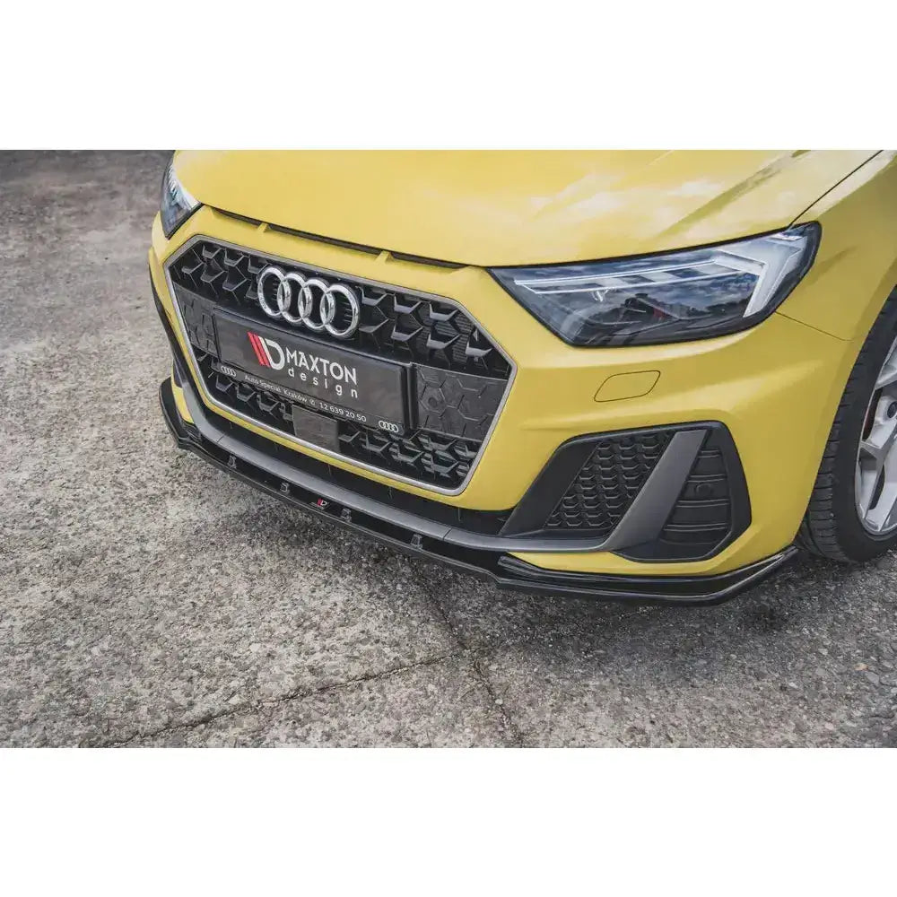 Front splitter på Audi A1 S-Line GB, gul bil med sort grill og plastdetaljer, sett skrått forfra.