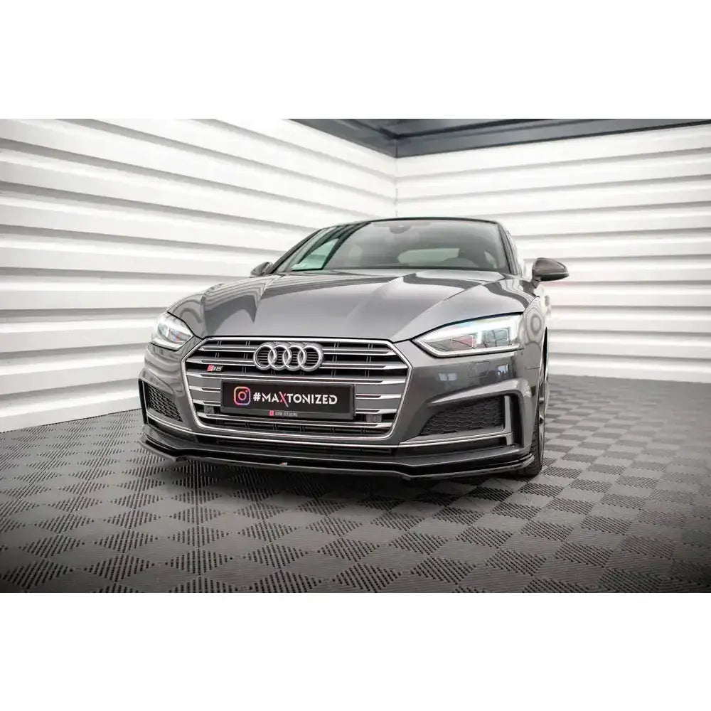 Frontsplitter på Audi A5 F5 S-Line med krom grilldetaljer, sett forfra i lyst rom med mørkt gulv.