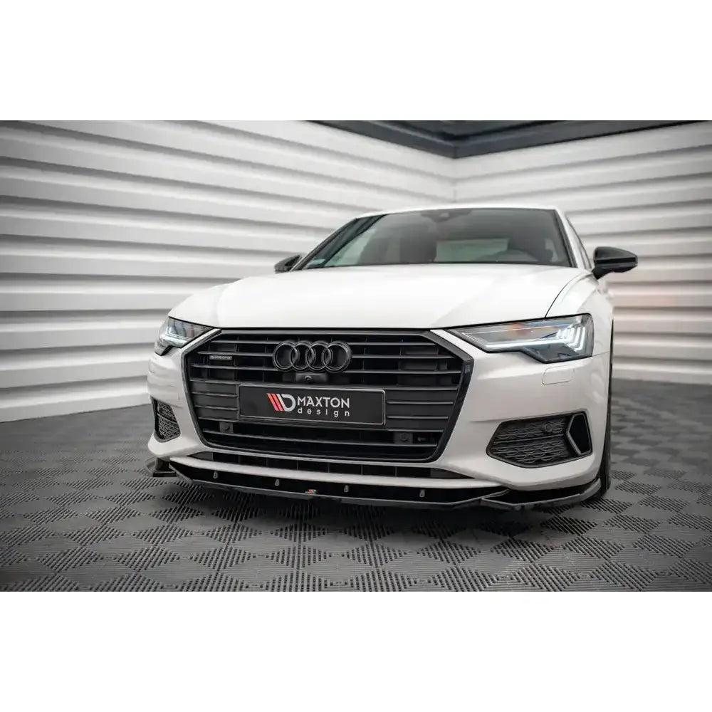 Front lip Audi A6 C8 V.1 montert på hvit bil med sort grill og markant frontspoiler sett forfra.
