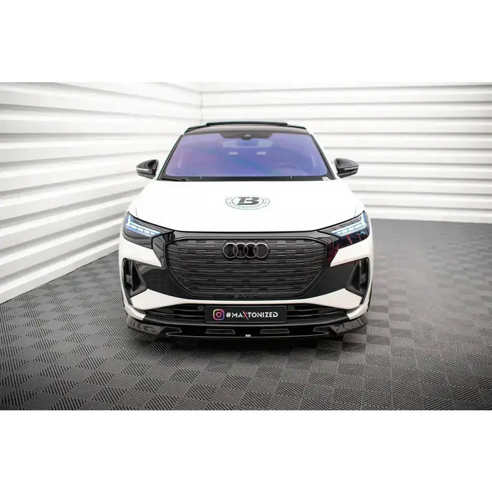 Frontsplitter på Audi Q4 e-tron Sportback Mk1, hvit bil med sort grill og LED-lys, sett forfra.