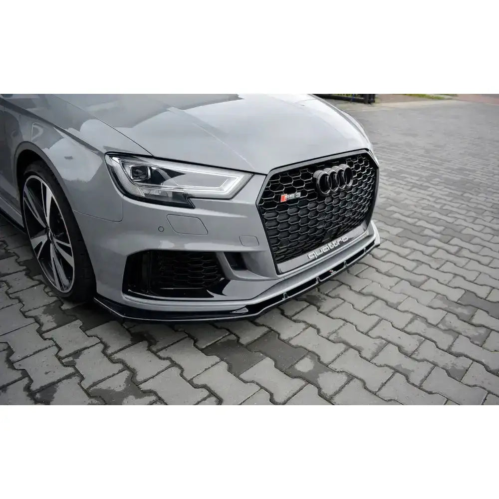 Frontsplitter på Audi RS3 8V FL sedan, nærbilde av sort grill og markert støtfanger på grå bil.