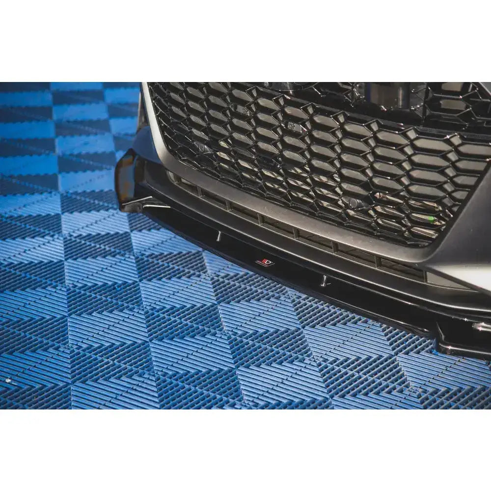 Front splitter for Audi RS6 C8, svart blank plast montert under grill, nærbilde fra skrå vinkel.