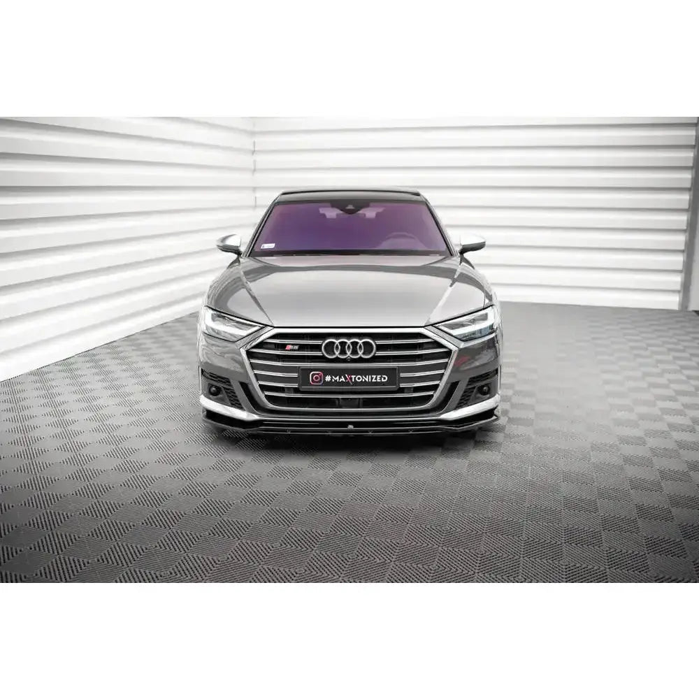 Frontspoiler på Audi S8 D5 V.1 sett forfra med kromgrill og røde S-emblemer innendørs.
