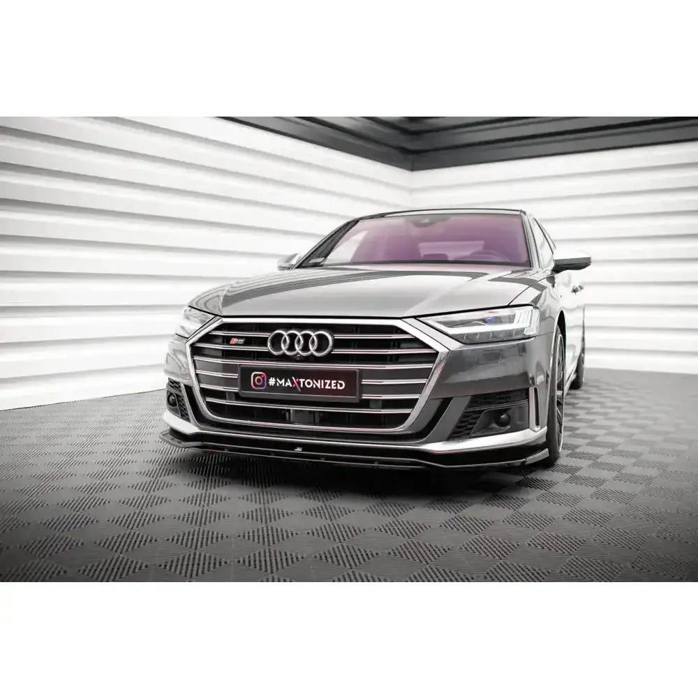 Frontsplitter på Audi S8 D5 V.1 sett forfra, mørk grå bil med kromgrill i lyst rom.