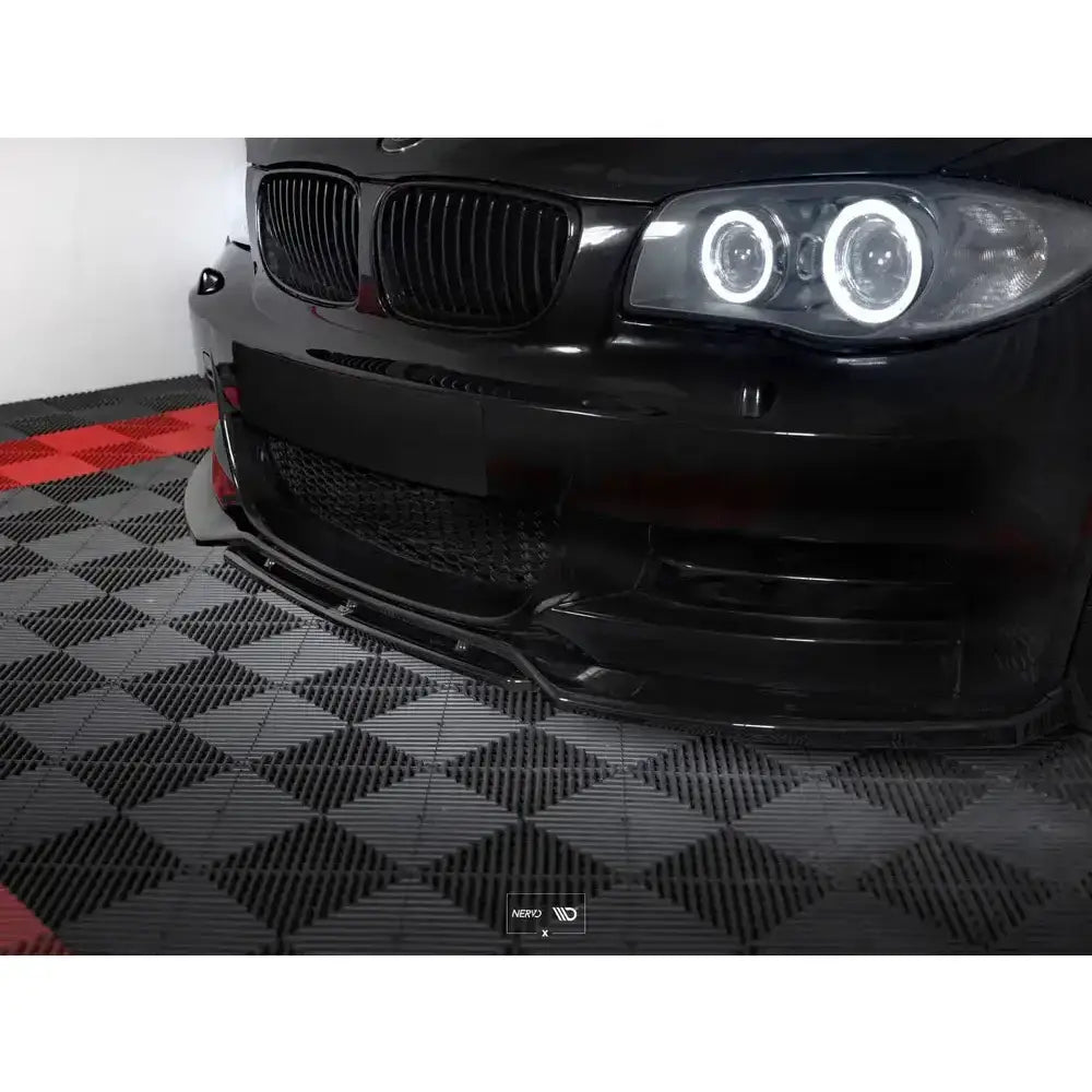 Frontsplitter på sort BMW 1 E82 Facelift M-Pack med LED-lys og sort grill, sett fra skrått venstre.