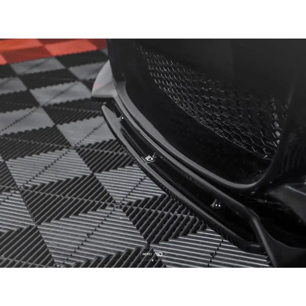 Front lip på Bmw 1 E82 Facelift M-Pack, nærbilde av svart spoiler med gittermønster og logo.