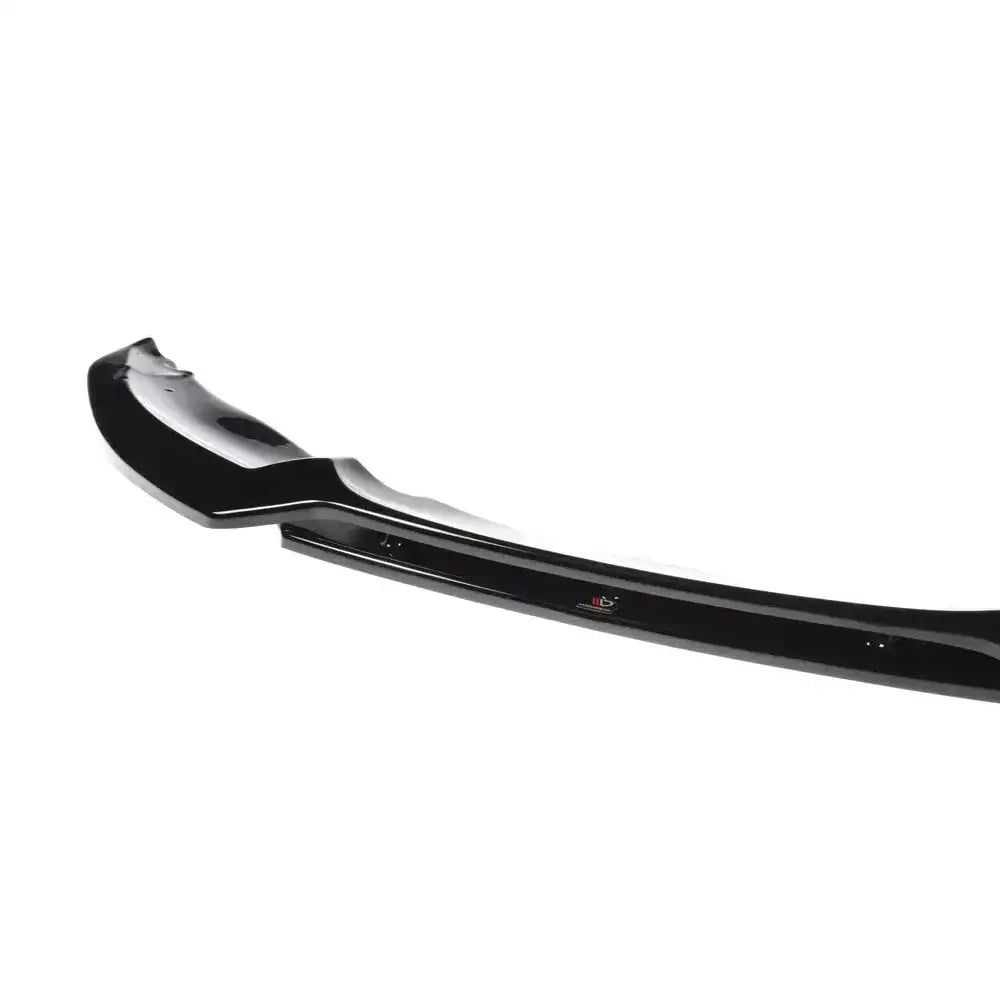 Frontspoiler til BMW 1 E82 Facelift M-Pack, sort og glanset plast, skrå vinkel, synlige monteringspunkter.