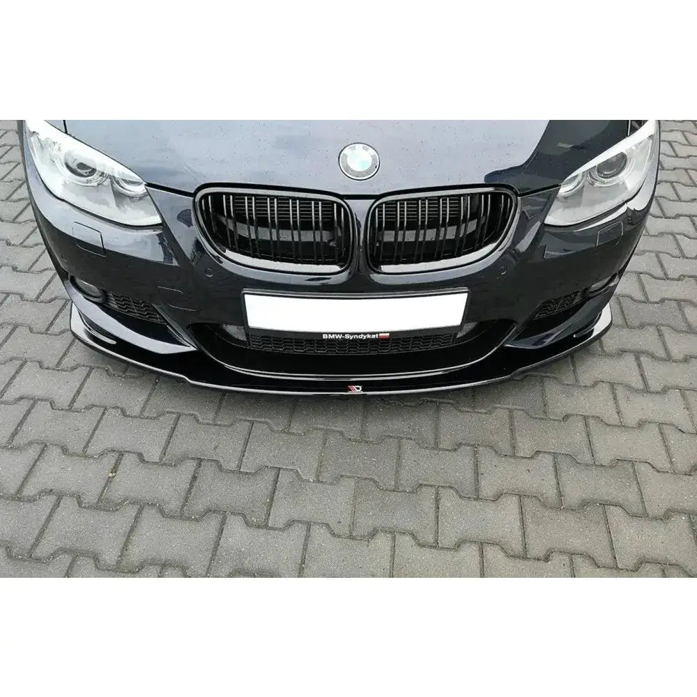 Frontsplitter til BMW 3 E92 M-Pack Facelift, blank sort, montert på bil foran mot brosteinsbakke.