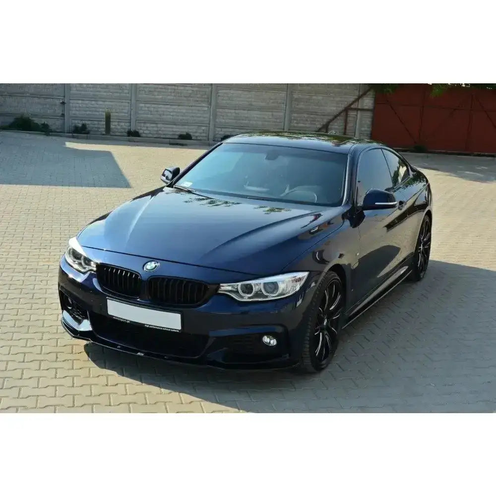 Frontspoiler på Bmw 4 F32 M-Pack, mørkeblå bil med sorte felger parkert på steinbelagt plass.