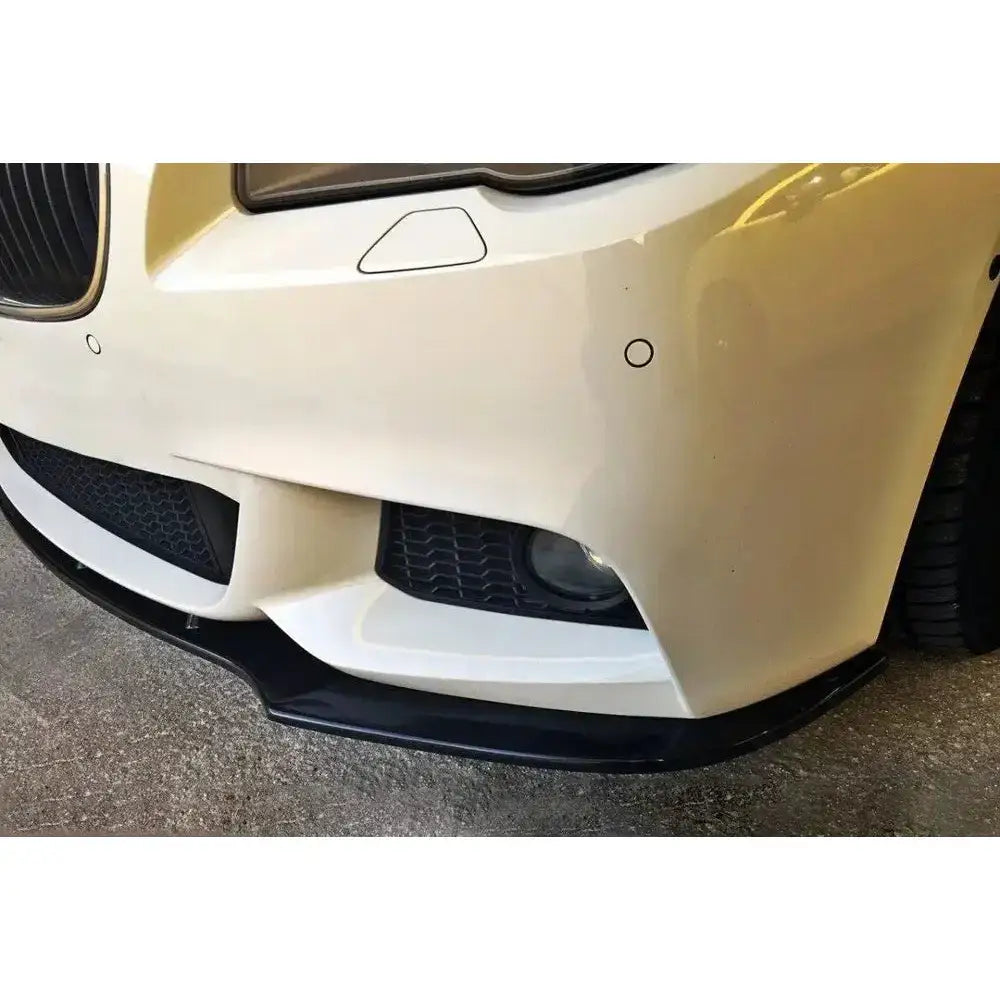 Frontsplitter til BMW 5 F10/F11 Mpack, nærbilde med sorte detaljer under hvit støtfanger.