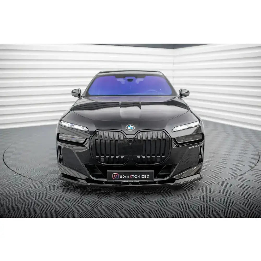 Frontspoiler på BMW 7 M-Pack G70, sort bil sett forfra med stor grill og smale frontlykter.