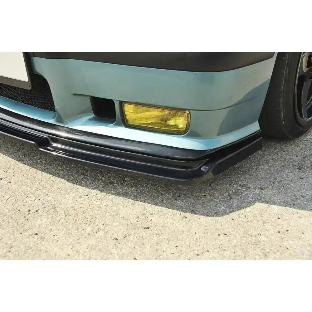 Frontsplitter på Bmw M3 E36 med svart spoiler under støtfanger og gult tåkelys mot asfalt.