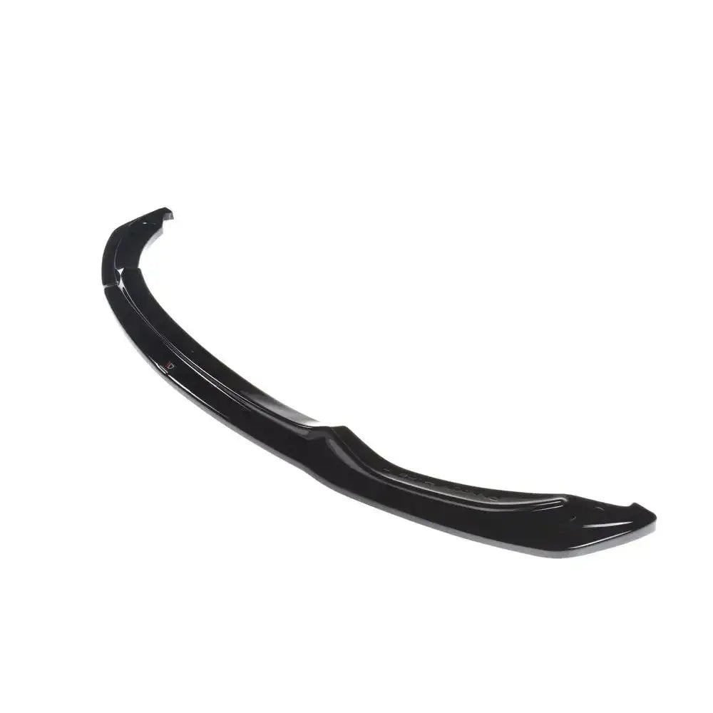 Frontspoiler til BMW M3 F80 V.1 i sort glanset plast, sett fra skrå vinkel mot hvit bakgrunn.