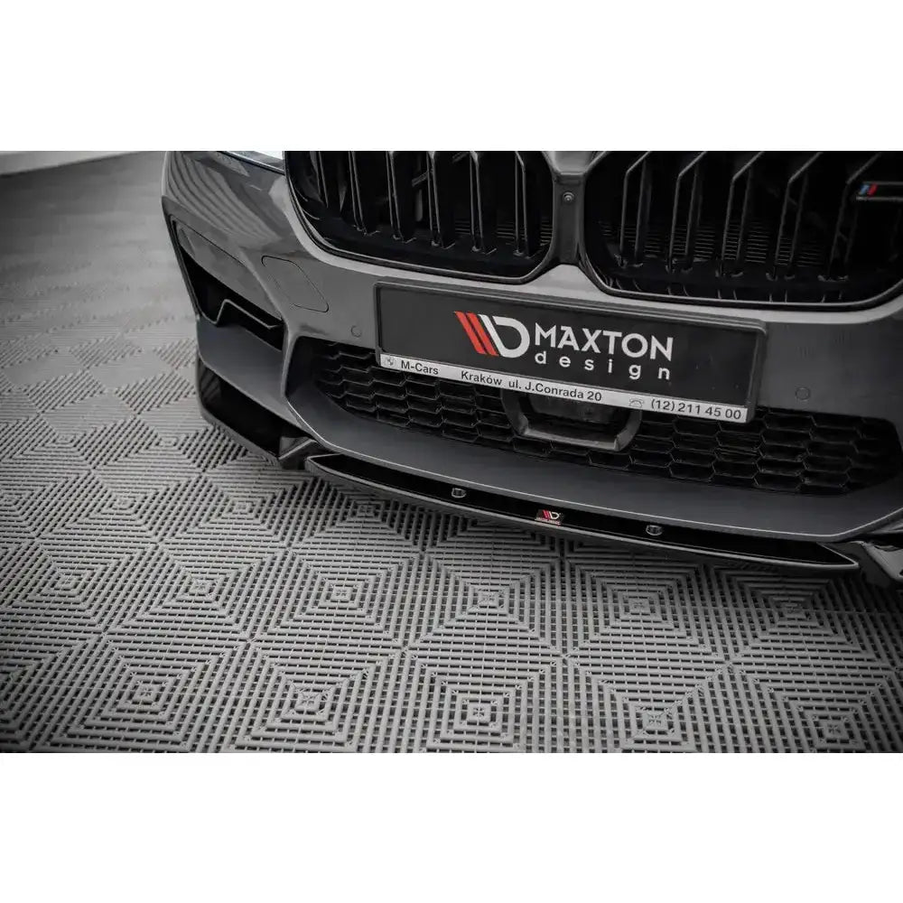 Front lip på BMW M5 F90 Facelift med sort frontsplitter, synlig logo og adresse på skiltet.