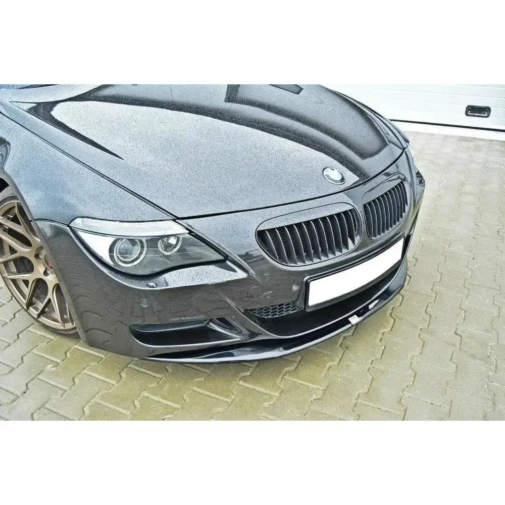 Frontsplitter på BMW M6 E63 med blank, lav plastspoiler, bronsefargede felger og fokus på fronten.
