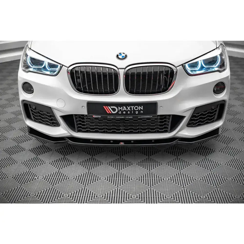Front lip på BMW X1 M-Pack F48 med svart frontsplitter og blå LED-lys, nærbilde av bilfronten.